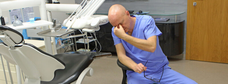 Dentiste fatigué en raison d'un éclairage incorrect dans la salle de traitement dentaire