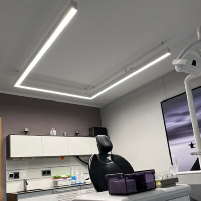 La lampe PHU White en forme de U à spectre complet de DentLed, installée dans une salle de soins moderne d'une clinique dentaire à Melle, permet un travail dentaire de précision.