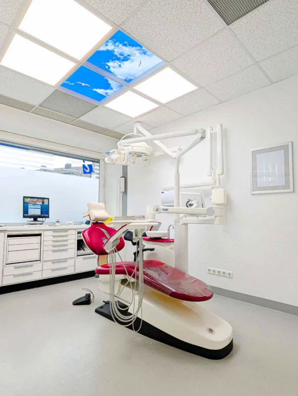 Salle de soins modernisée au cabinet Zahnarztpraxis Dr. Grünewald avec plafonds photo Dentled et éclairage LED lumière du jour naturel.