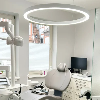 Anneau Dentled PVR120 installé dans la salle de soins du cabinet dentaire Herrmann & Langl, offrant un éclairage dentaire professionnel à spectre complet.