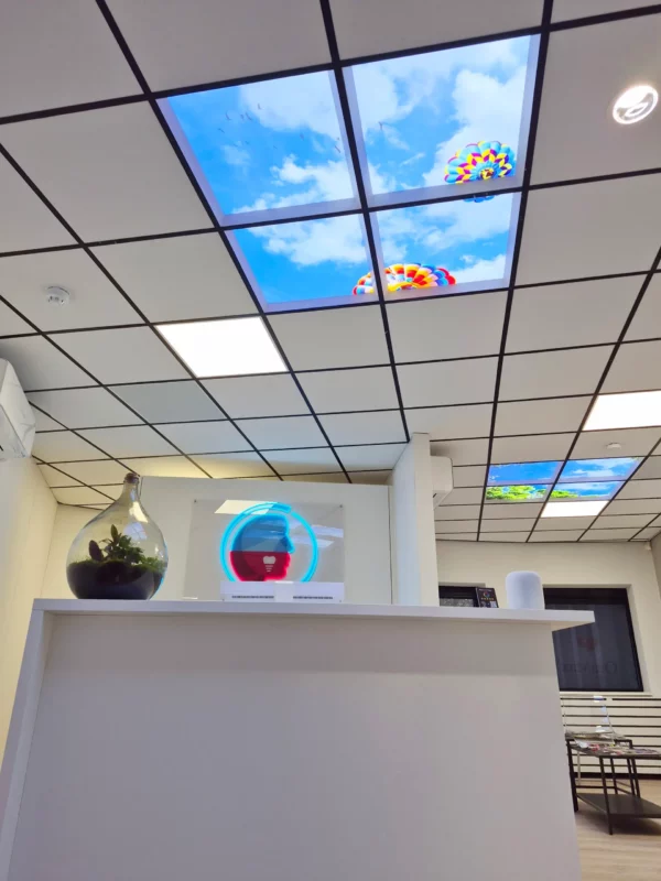 Design contemporain de cabinet dentaire avec des panneaux photo de plafond Dentled à OraMax Clinics Breda.