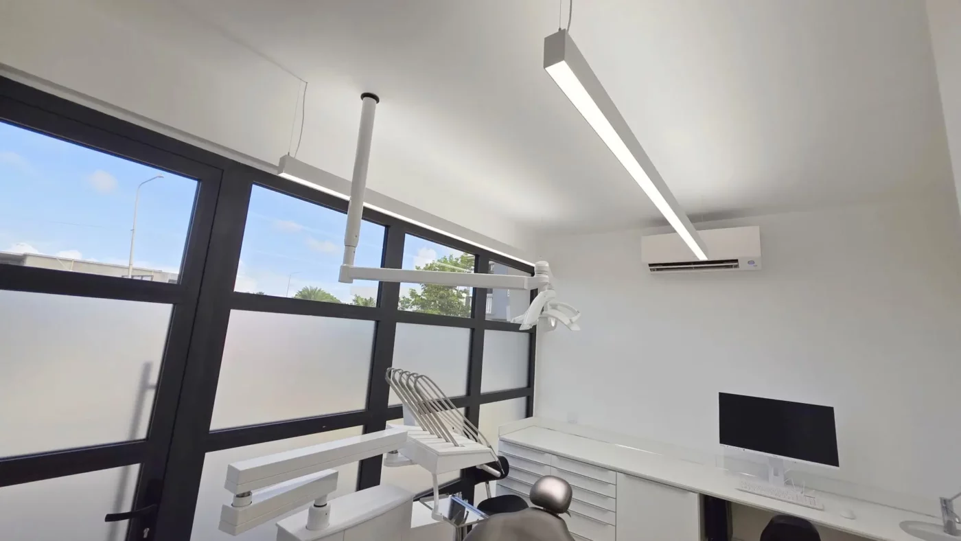 Salle de soins dentaires moderne chez Coral Dental Bonaire, bénéficiant d’un éclairage direct et indirect équilibré grâce aux luminaires LED Dentled PHL22.