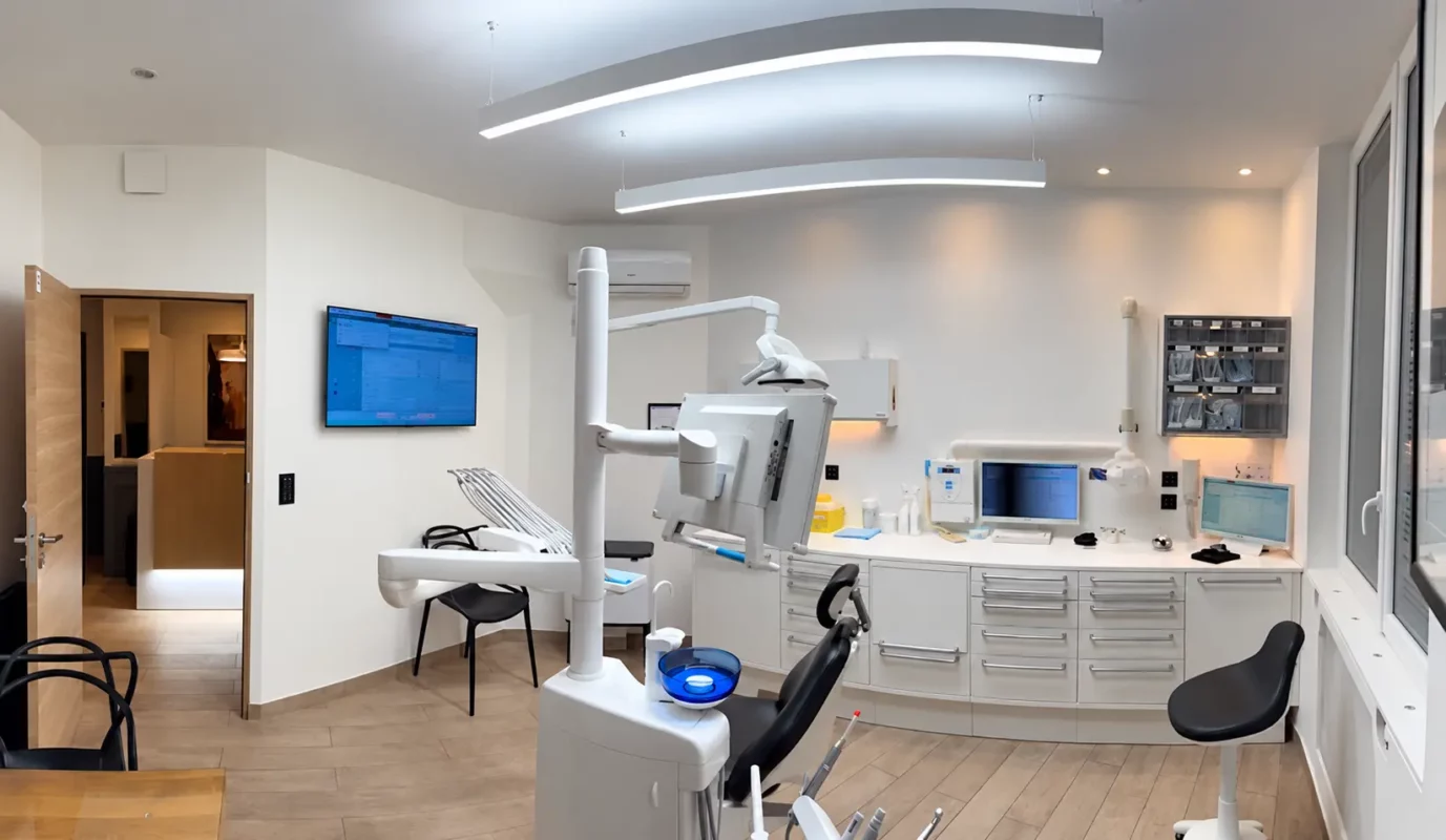 Vue d’ensemble de la salle de soins du Dr Didier Achour à Paris, avec les luminaires suspendus et l’unité dentaire.